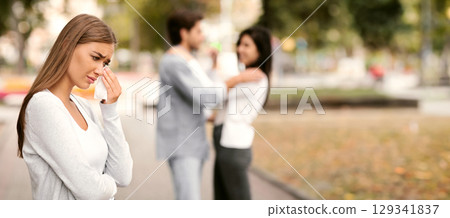 Infidelity. Sad Girl Crying Seeing Her Cheating Boyfriend Hugging Other Woman In Park. Selective Focus 129341837