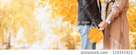 Cropped of man and woman in park holding bunch of yellow leaves, copy space 129341922