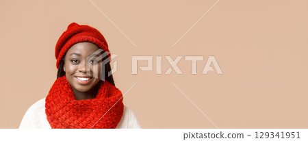 Portrait of black smiling woman in red knitted winter set over beige background, panorama with copy space Portrait of black smiling woman in red knitted winter set over beige background, panorama with copy space 129341951
