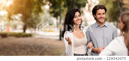 Friendship With Ex. Girl Talking With Married Couple Of Friends Walking In Park Outside. Selective Focus 129342075
