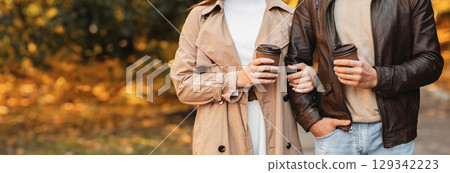 Cropped photo of couple drinking coffee or tea at park Cropped photo of couple drinking coffee or tea at park 129342223