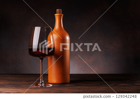 Wine glass filled with wine beside a bottle Wine glass filled with wine beside a bottle 129342248