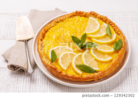 Delicious lemon tart with golden crust and smooth, glossy lemon filling Delicious lemon tart with golden crust and smooth, glossy lemon filling 129342302