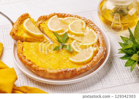 Delicious lemon tart with golden crust and smooth, glossy lemon filling Delicious lemon tart with golden crust and smooth, glossy lemon filling 129342303