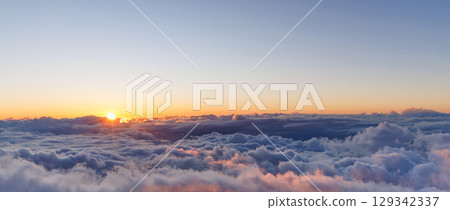 Sunset above the clouds with warm colors and soft light 129342337