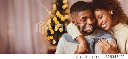 Couple in love spending christmas eve, hugging and enjoying evening at home 129342431