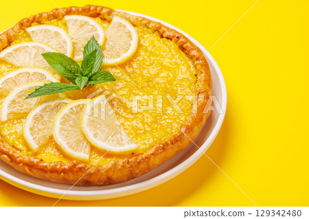 Delicious lemon tart with golden crust and smooth, glossy lemon filling 129342480