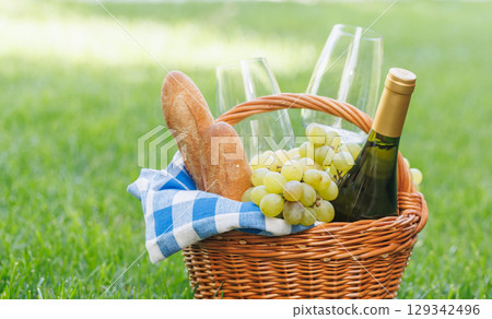 Picnic basket with wine, grapes, and baguette Picnic basket with wine, grapes, and baguette 129342496