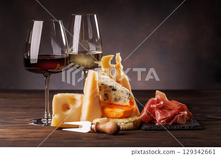 Assorted cheeses paired with glasses of wine on a rustic table Assorted cheeses paired with glasses of wine on a rustic table 129342661
