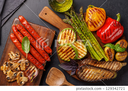 Assorted grilled vegetables including bell peppers, zucchini, eggplant, and sausages 129342721