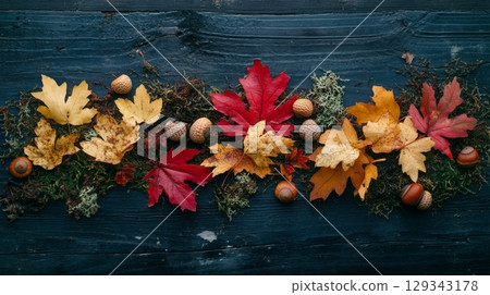 Vibrant red, orange, and yellow leaves are arranged with acorns and moss on a dark wooden background, showcasing the beauty of fall. Vibrant red, orange, and yellow leaves are arranged with acorns and moss on a dark wooden background, showcasing the beauty of fall. 129343178