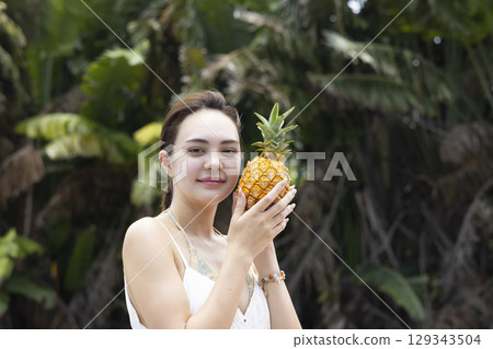 Woman with pineapple 129343504
