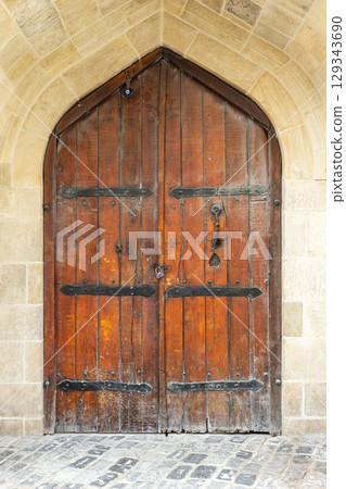 Wooden Arched Door with Rustic Iron Hinges and Brick Surround Wooden Arched Door with Rustic Iron Hinges and Brick Surround 129343690