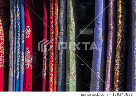 Colorful Traditional Fabrics with Intricate Patterns Displayed in a Retail Setting 129343698
