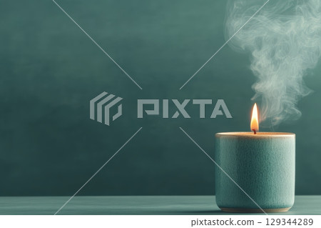 Candle burning gently on a serene table with smoke curling softly at dusk 129344289