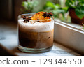 Vegan pumpkin latte with oat milk and a hint of cardamom and orange slice on window sill 129344550