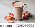 Maple salt latte in a clear glass mug, on marble surface, autumn leaves decor 129344558