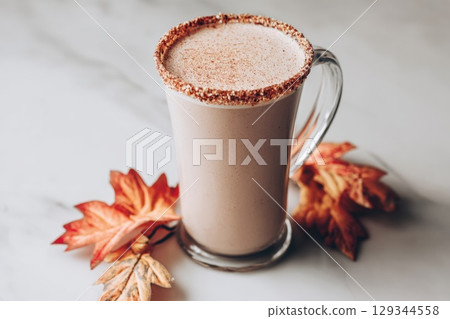 Maple salt latte in a clear glass mug, on marble surface, autumn leaves decor Maple salt latte in a clear glass mug, on marble surface, autumn leaves decor 129344558
