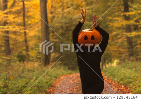 Person in Pumpkin Costume in Autumn Forest 129345164