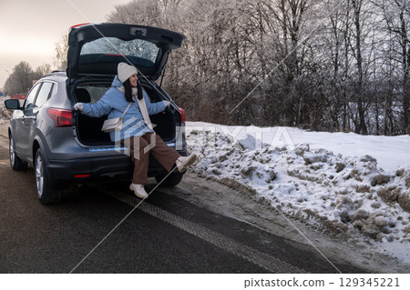 Woman Relaxing in Car on Snowy Road Woman Relaxing in Car on Snowy Road 129345221