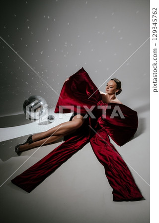 Elegant Woman in Red Dress with Disco Ball Elegant Woman in Red Dress with Disco Ball 129345762