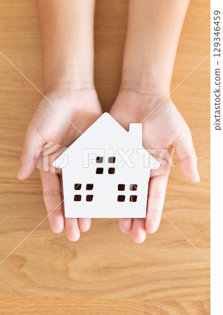 Elementary school boy holding a model of a house 129346459