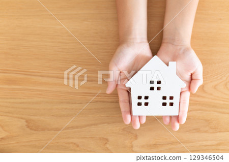 Elementary school boy holding a model of a house Elementary school boy holding a model of a house 129346504