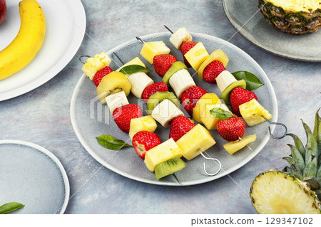 Plate of mixed fruits on skewers. Plate of mixed fruits on skewers. 129347102