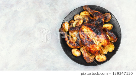 Roasted, baked chicken with potatoes and apples. 129347130