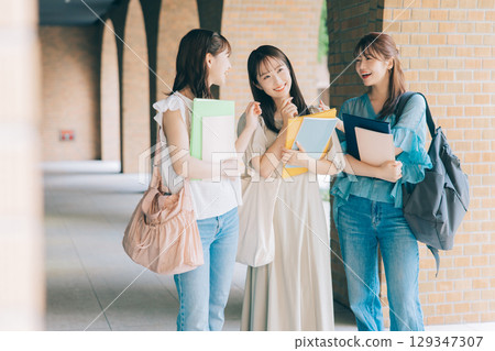 Three college students walking on campus 129347307