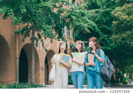 Three college students walking on campus 129347308
