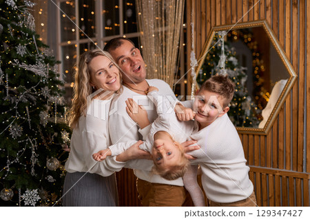 Happy young family parents and children gathering together on Christmas. Cheerful family of four in 129347427