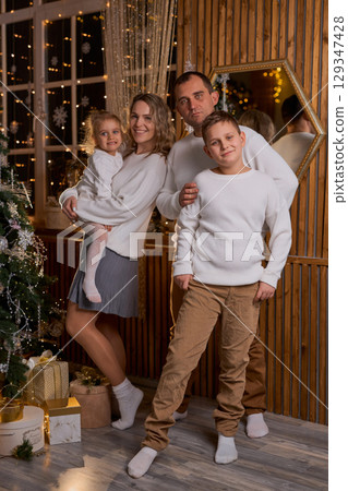 Happy young family parents and children gathering together on Christmas. Cheerful family of four in Happy young family parents and children gathering together on Christmas. Cheerful family of four in 129347428