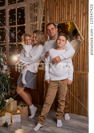 Happy young family parents and children gathering together on Christmas. Cheerful family of four in Happy young family parents and children gathering together on Christmas. Cheerful family of four in 129347429