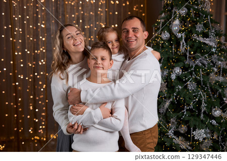 Happy young family parents and children gathering together on Christmas. Cheerful family of four in Happy young family parents and children gathering together on Christmas. Cheerful family of four in 129347446