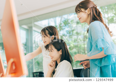 觀看計算機的三名婦女 129347499