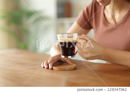 Woman hand puting coasters on a table to leave coffee cup 129347962