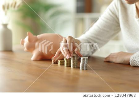 Woman hands counting savings on wooden table 129347968