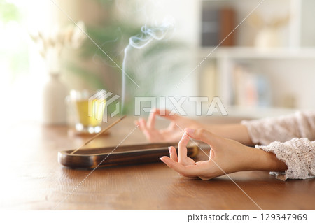 Woman hands relaxing doing yoga burning incense stick 129347969