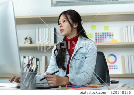Focused Work. Young woman concentrating on digital design at her computer. Focused Work. Young woman concentrating on digital design at her computer. 129348136