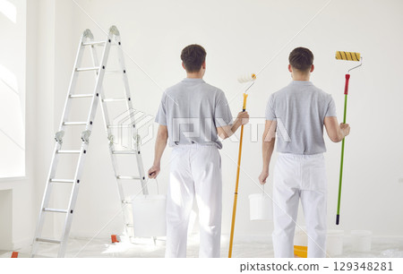 Back two painters in uniform look at the wall, close-up Back two painters in uniform look at the wall, close-up 129348281
