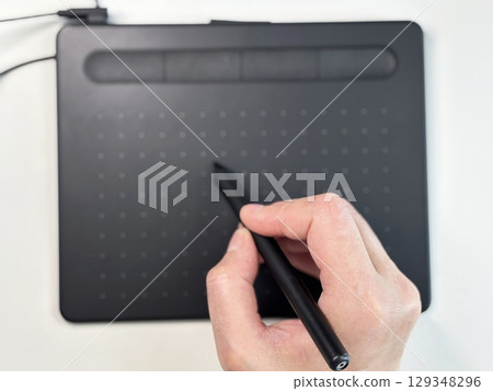 Creative business woman graphic designer working with stylus on digital tablet at modern bright office desk. Freelance artist drawing illustration. Creative professions and productivity concept 129348296