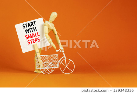 Start with small steps symbol. Concept words phrase Start with small steps on beautiful white paper on clothespin. Beautiful orange background. Business Start with small steps concept. Copy space. 129348336