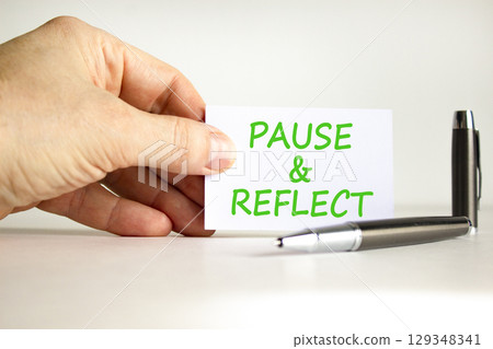 Pause and reflect symbol. Concept words Pause and reflect on beautiful note. Beautiful white background. Businessman hand, pen. Business motivational lifestyle pause and reflect concept. Copy space. 129348341