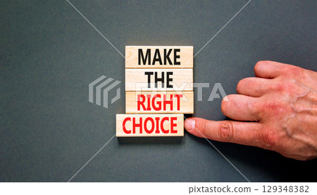 Make the right choice symbol. Concept words phrase Make the right choice on beautiful wooden blocks. Beautiful grey background. Businessman's hand. Business Make the right choice concept. Copy space. 129348382