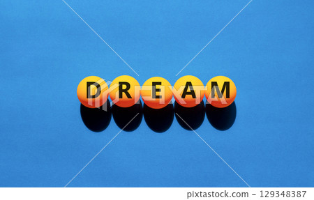 Dream symbol. Concept word Dream on beautiful yellow tennis ping pong balls. Beautiful wooden table wooden background. Business lifestyle dream concept. Copy space. Dream symbol. Concept word Dream on beautiful yellow tennis ping pong balls. Beautiful wooden table wooden background. Business lifestyle dream concept. Copy space. 129348387