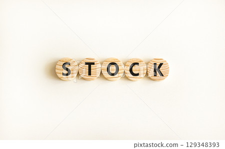 Stock symbol. Concept word Stock on beautiful wooden circles. Beautiful white table white background. Business lifestyle stock concept. Copy space. Stock symbol. Concept word Stock on beautiful wooden circles. Beautiful white table white background. Business lifestyle stock concept. Copy space. 129348393