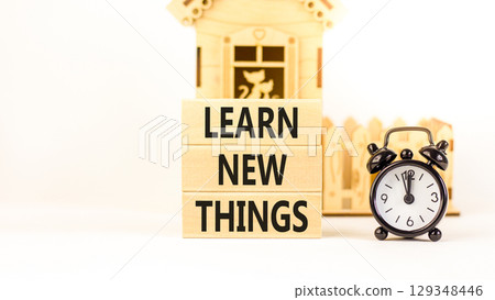 Learn new things symbol. Concept words Learn new things on beautiful wooden blocks. Beautiful white background. Black alarm clock. Business motivational learn new things concept. Copy space. 129348446