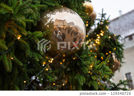Close-up of golden Christmas bauble with reflection of festive market 129348728