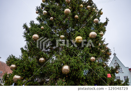 Decorated Christmas tree with golden baubles in old town square 129348729